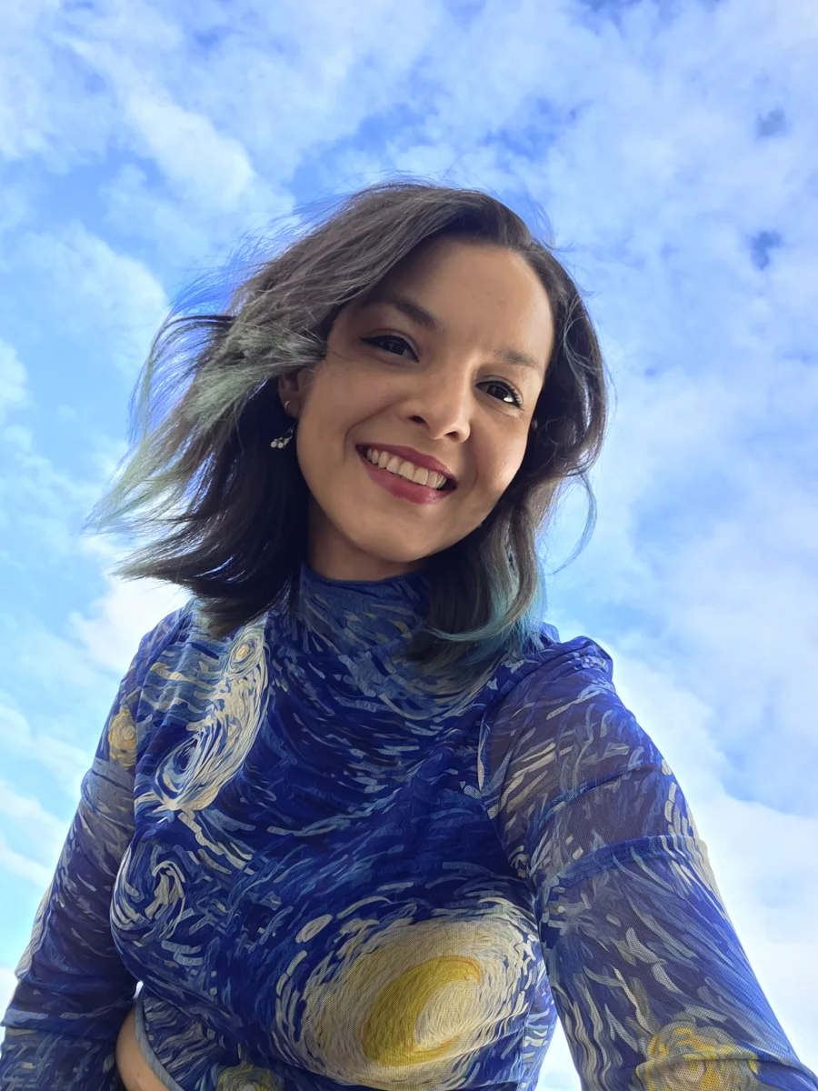 María Ilse Dovale sonriendo bajo un cielo azul
